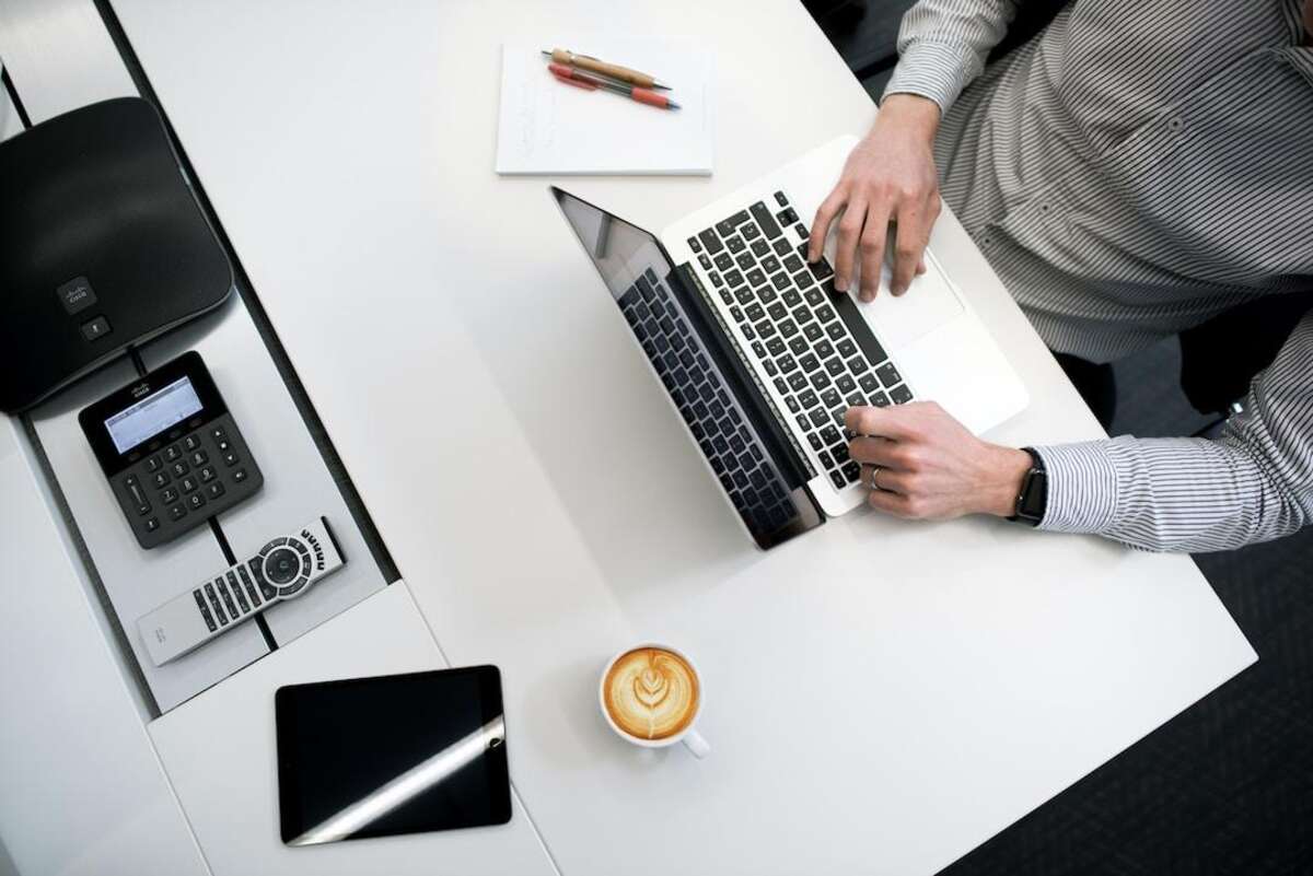 Top view of businessman embracing technology to prevent revenue leakage with laptop